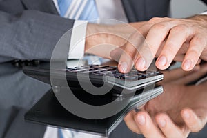 Accountant calculating tax using calculator photo