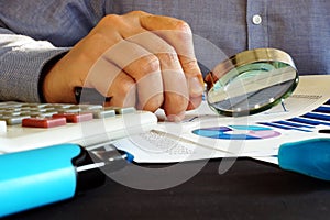 Accountant checking financial report with magnifying glass. Accounting. photo