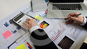 Accountant counting on calculator and holding documents in hand close-up Accounting concept with laptop