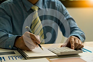 Accountant holding pen and using calculator doing company taxes on wooden table in office tax, accounting,