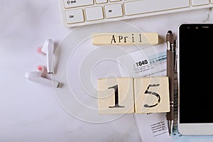 Accountant office, income tax return place on table with 1040 U.S tax forms of the deadline time April 15