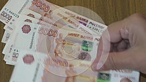 The accountant recalculates the money received manually. Banknotes of the Russian Federation with a nominal value of  5 000 rubles