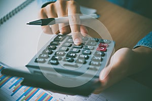 The accountant`s hand is using the calculator. For cost analysis Profit and loss and tax calculation concept preparation of