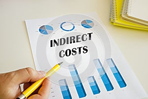 Accountant shows to the sign INDIRECT COSTS sign on the financial document