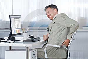 Accountant Suffering From Back Pain At Desk