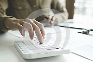 Accountant using calculator for calculate finance report in office.