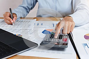 accountant using calculator with pen on desk for calculate finance dat