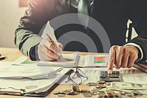 accountant using calculator to calculate budget on desk in office. business finance and accounting