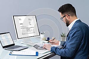 Accountant using computer to manage invoices