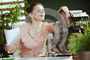 accountant woman in green office suffer from heat