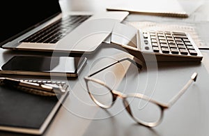 Accountant workplace, calculator, laptop computer and glasses at office desk, finance, accounting concept