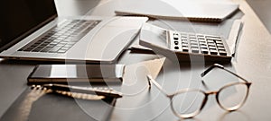 Accountant workplace, calculator, laptop computer and glasses at office desk panoramic banner, finance, accounting co