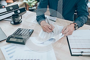 Accountant writing, checking and working on company data, document, report and calculator to calculate  on desk office. Accounting
