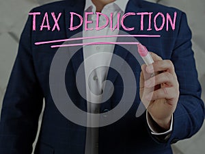 Accountant writing TAX DEDUCTION on screen by a pink pen