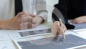 Accountants and financiers are brainstorming the analysis of revenue performance with stock graphs at meetings