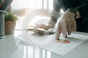 Accountants work analyzing financial reports on a laptop at his office, business analytics concept