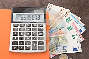 Accounting and business management Banknotes, calculator andEuro banknotes on wooden background. Photo for tax, debit and costing.