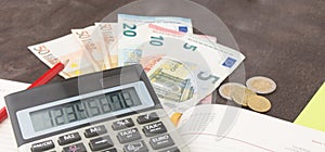 Accounting and business management Banknotes, calculator and Euro banknotes on wooden background. Tax, debit and costing. photo