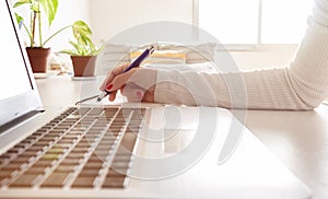 Accounting businesswoman working using laptop at home, telecommuting, working remotely during quarantine