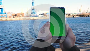 Accounting for cargo in the port. Smartphone with green screen