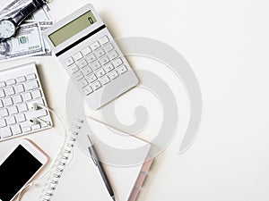 Accounting concept with keyboard, smartphone, notebook, coffee cup, calculator and money on white table background.