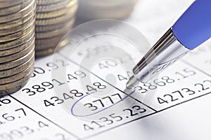 Accounting document with pen, money, coins and checking financial chart. Concept of banking, financial report and financial audit