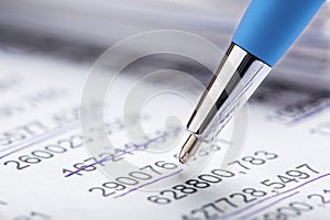 Accounting document with pen, money, coins and checking financial chart. Concept of banking, financial report and financial audit