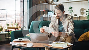 Accounting at Home: Streessed Man Using Laptop Computer, Filling Tax Forms. Businessman Scared of photo