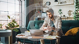 Accounting at Home: Streessed Man Using Laptop Computer, Filling Tax Forms. Businessman Scared of photo