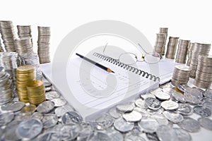 Accounting ledger between piles of coins