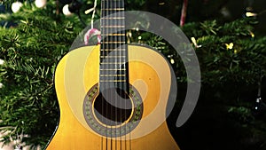 Accoustic guitar in front of Christmas tree