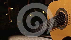 Accoustic guitar in front of Christmas tree