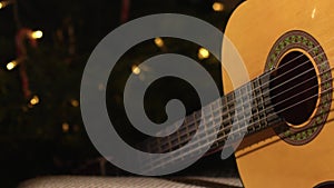 Accoustic guitar in front of Christmas tree