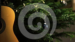 Accoustic guitar in front of Christmas tree