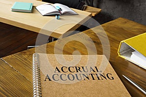 Accrual accounting guide near a folder on the table.