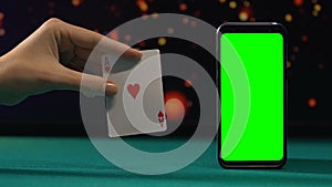 Ace of hearts near green screen smartphone, winning combination, online casino