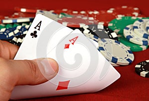 Ace pair in male hands on poker chips background