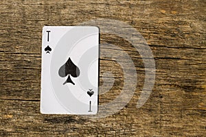 Ace of spades on old wooden background