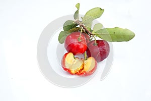 Acerola Cherry with half slice and green leaves isolated on white background