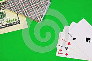 Aces, a deck of cards and money on the green background of the game table.