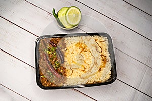 Achari beef pulao biryani rice with cucumber and lemon slice served in dish isolated on wooden table top view of bangladeshi and