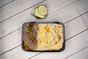 Achari beef pulao biryani rice with cucumber and lemon slice served in dish isolated on wooden table top view of bangladeshi and