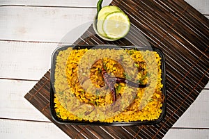 Achari chicken khichuri biryani rice pulao with cucumber and lemon slice served in dish isolated on wooden table top view of