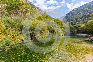 Acheron river in Greece, blue sky, mountains, forest