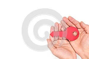 Achieve goal, success and finding solution concept. Young male hands holding a red key top view in white background.