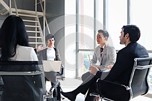 Achievement successful businessman and woman having serious discussion about work at conference meeting desk, five businesspeople