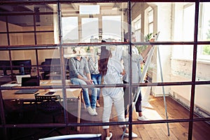 Achieving best results. Modern young man conducting a business presentation while standing behind the glass wall in the