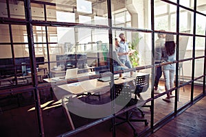 Achieving best results. Modern young man conducting a business presentation while standing behind the glass wall in the