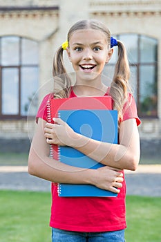 Achieving high standards. Cute little bookworm. Cute smiling small child hold books educational institution background