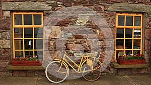 Yellow bike against stone wall and yellow window photo